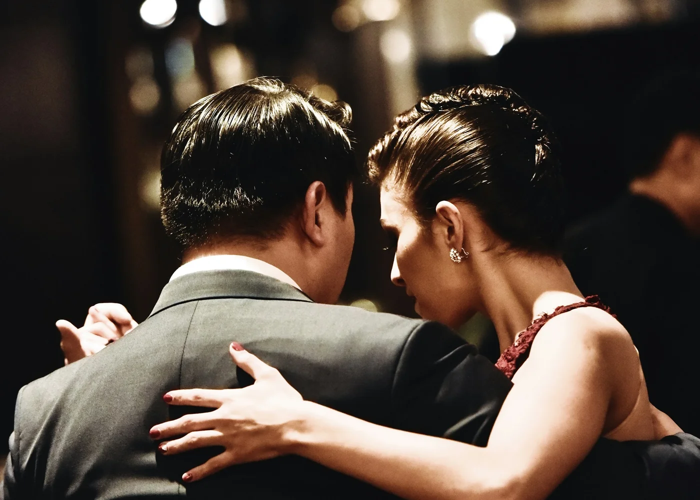 A tango couple seen from behind in close embrace, formal dress, representative of the show's dance couples